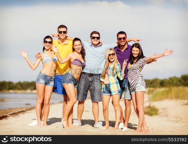 summer, holidays, vacation, happy people concept - group of friends having fun on the beach