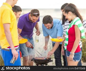 summer, holidays, vacation, happy people concept - group of friends having picnic and making barbecue on the beach