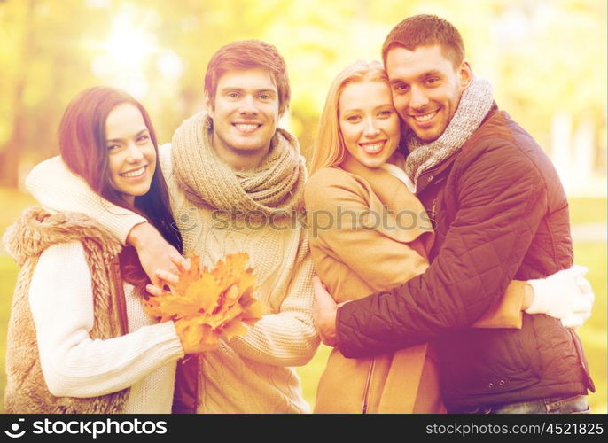 summer, holidays, vacation, happy people concept - group of friends or couples having fun in autumn park