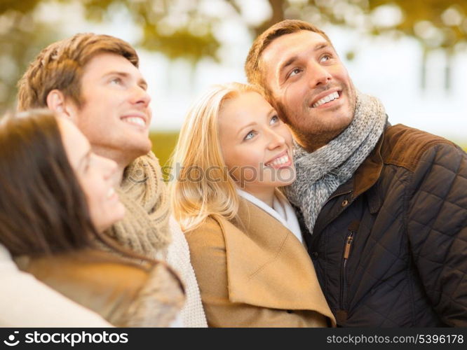 summer, holidays, vacation, happy people concept - group of friends or couples having fun in autumn park