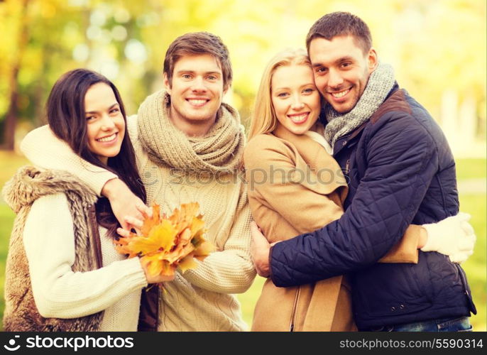 summer, holidays, vacation, happy people concept - group of friends or couples having fun in autumn park