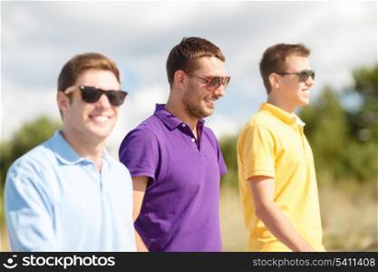 summer, holidays, vacation, happy people concept - group of friends walking on the beach
