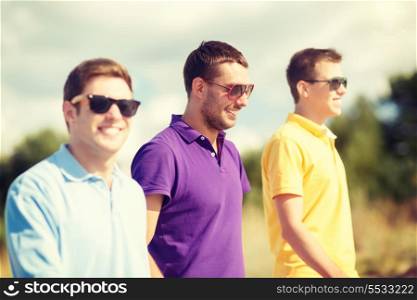 summer, holidays, vacation, happy people concept - group of friends walking on the beach