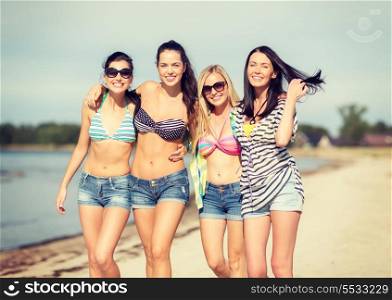 summer, holidays, vacation, happy people concept - group of girls in bikinis walking on the beach