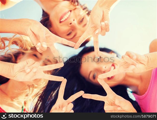 summer, holidays, vacation, happy people concept - group of girls looking down and showing finger five gesture