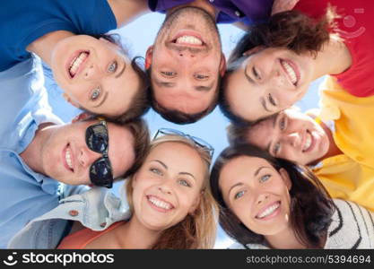 summer, holidays, vacation, happy people concept - group of teenagers looking down