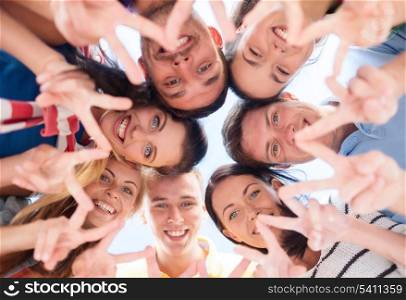 summer, holidays, vacation, happy people concept - group of teenagers looking down and showing finger five gesture