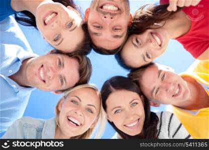 summer, holidays, vacation, happy people concept - group of teenagers looking down