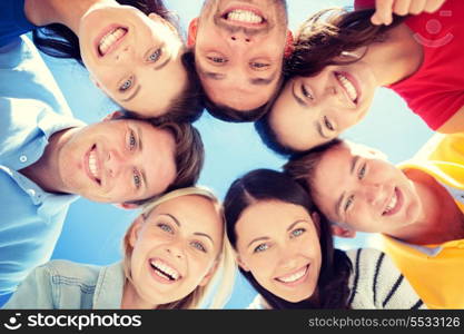 summer, holidays, vacation, happy people concept - group of teenagers looking down