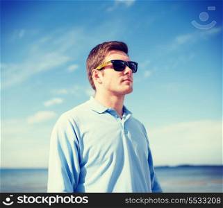 summer, holidays, vacation, happy people concept - man in sunglasses on the beach