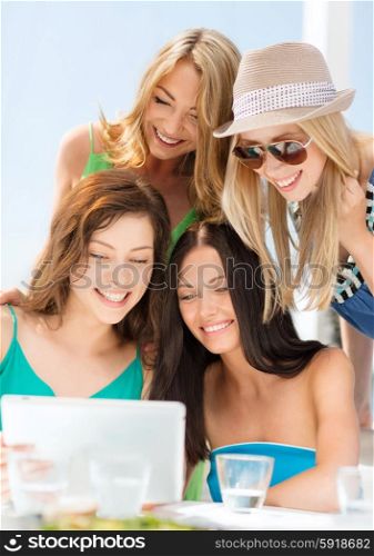 summer holidays, vacation, internet and technology concept - smiling girls looking at tablet pc in cafe