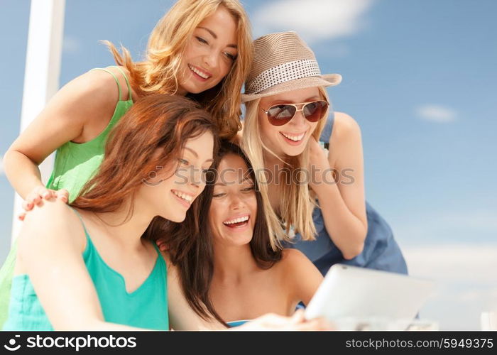 summer holidays, vacation, internet and technology concept - smiling girls looking at tablet pc in cafe