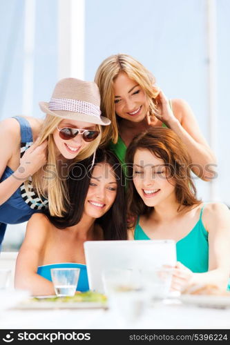 summer holidays, vacation, internet and technology - girls looking at tablet pc in cafe