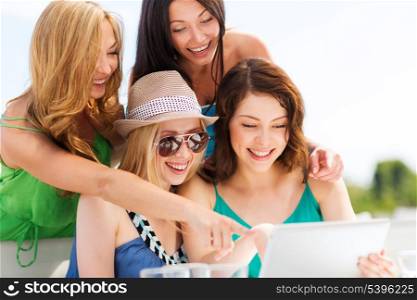 summer holidays, vacation, internet and technology - girls looking at tablet pc in cafe