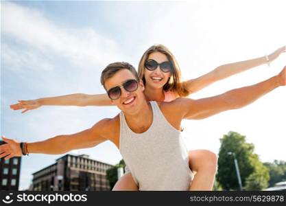 summer, holidays, vacation, love and friendship concept - smiling couple having fun in city