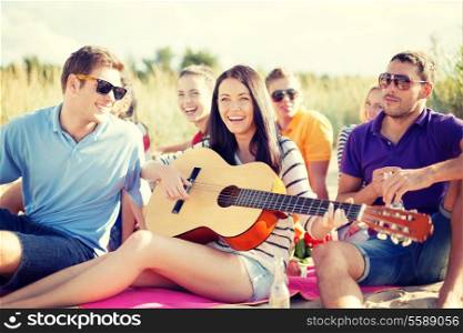 summer, holidays, vacation, music, happy people concept - group of friends with guitar having fun on the beach
