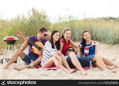 summer holidays, vacation, music, happy people concept - group of happy friends having picnic and playing guitar on beach