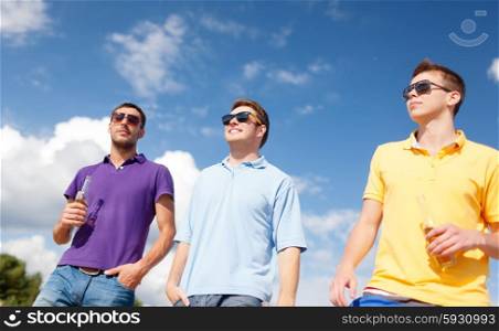 summer holidays, vacation, people and bachelor party concept - group of happy male friends drinking beer and walking along beach