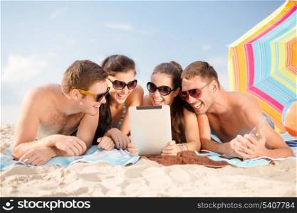 summer, holidays, vacation, technology and happy people concept - group of smiling people in sunglasses with tablet pc on the beach