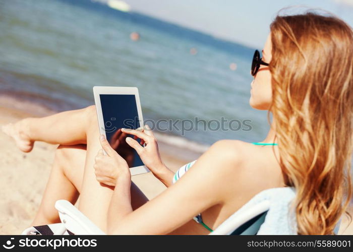 summer holidays, vacation, technology and internet - girl looking at tablet pc on the beach chair