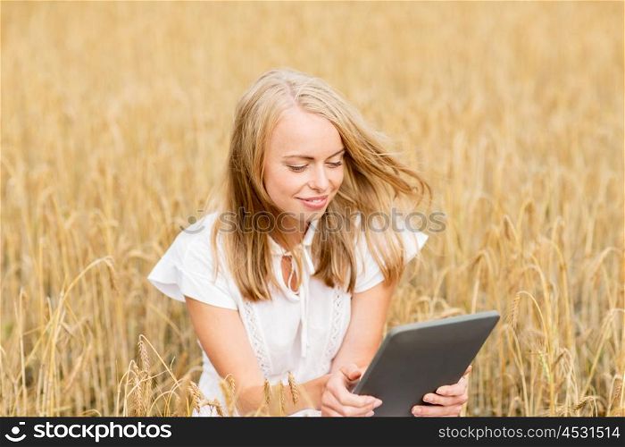 summer holidays, vacation, technology and people concept - smiling young woman in white dress with tablet pc computer on cereal field