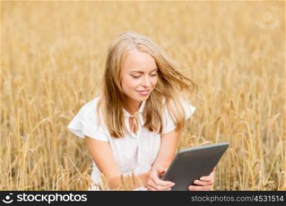 summer holidays, vacation, technology and people concept - smiling young woman in white dress with tablet pc computer on cereal field