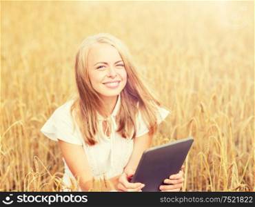 summer holidays, vacation, technology and people concept - smiling young woman in white dress with tablet pc computer on cereal field. happy young woman with tablet pc on cereal field