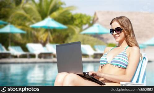 summer holidays, vacation, technology, people and internet - happy young woman in shades with laptop computer over exotic beach with palm trees and pool background