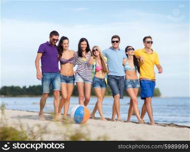 summer holidays, vacation, tourism, travel and people concept - group of happy friends with inflatable ball walking along beach