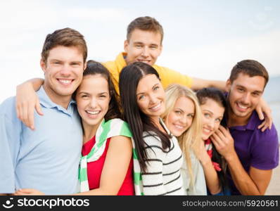 summer holidays, vacation, tourism, travel and people concept - group of happy friends hugging on beach