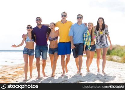 summer holidays, vacation, tourism, travel and people concept - group of happy friends walking along beach