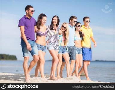 summer holidays, vacation, tourism, travel and people concept - group of happy friends walking along beach