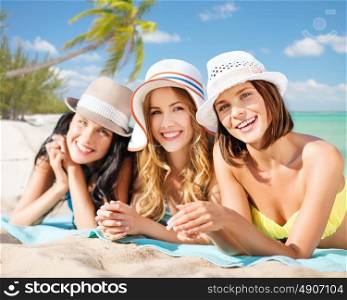 summer holidays, vacation, travel and people concept - group of smiling young women in hats lying over exotic tropical beach with palm trees background. group of happy women in hats sunbathing on beach