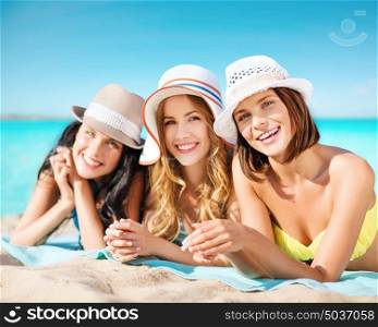 summer holidays, vacation, travel and people concept - group of smiling young women in hats lying over exotic tropical beach background. group of happy women in hats sunbathing on beach
