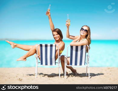 summer holidays, vacation, travel and tourism people concept - smiling young women with drinks sunbathing over exotic tropical beach background. happy young women with drinks sunbathing on beach