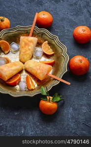 Summer ice cream with fruit. Tasty ice cream with tangerines in copper dish