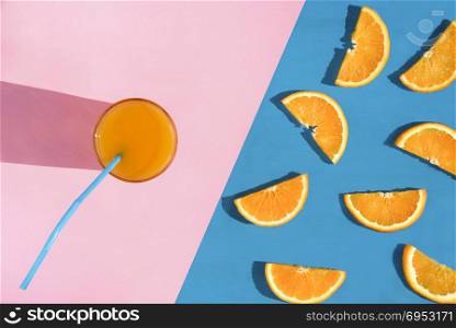 Summer image from a high angle view with a glass of healthy orange juice and a multitude of orange slices