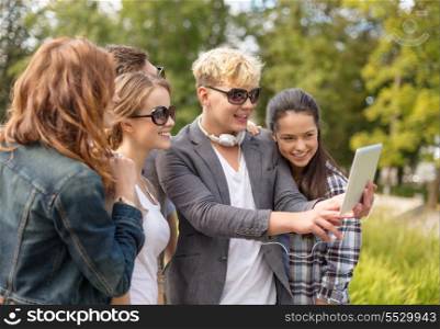 summer, internet, social networking, technology and teenage concept - group of teenagers taking photo with tablet pc outside