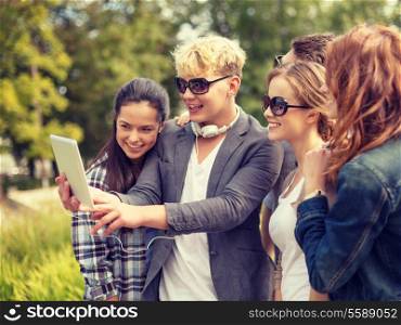 summer, internet, social networking, technology and teenage concept - group of teenagers taking photo with tablet pc outside