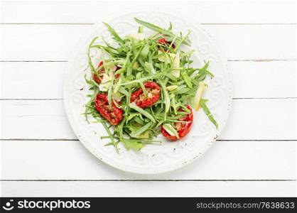 Summer Italian salad with arugula and sun dried tomatoes. Green salad with sun dried tomato