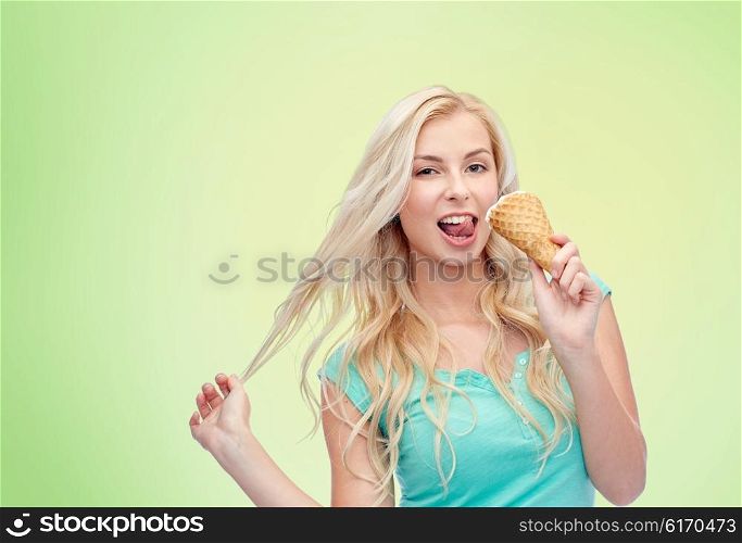 summer, junk food and people concept - young woman in sunglasses eating ice cream over green natural background