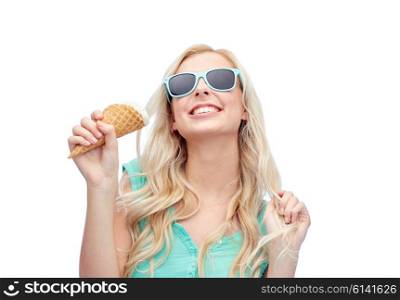 summer, junk food and people concept - young woman or teenage girl in sunglasses eating ice cream