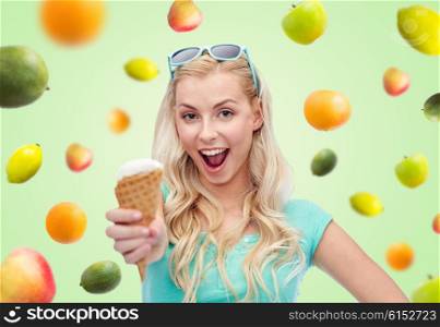 summer, junk food and people concept - young woman or teenage girl in sunglasses eating ice cream over green background with fruits