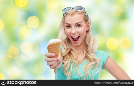 summer, junk food and people concept - young woman or teenage girl in sunglasses eating ice cream over summer green lights background