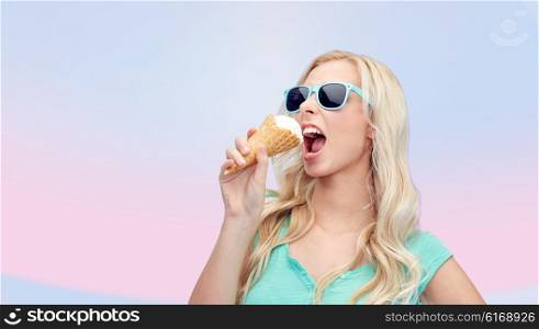 summer, junk food and people concept - young woman or teenage girl in sunglasses eating ice cream over pink background
