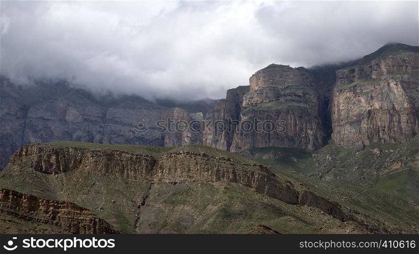 Summer landscape in the mountains. Mountain range shrouded in a cloud of fog.