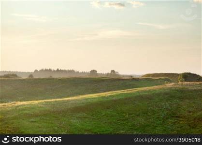 Summer landscape on sunset - field and hills