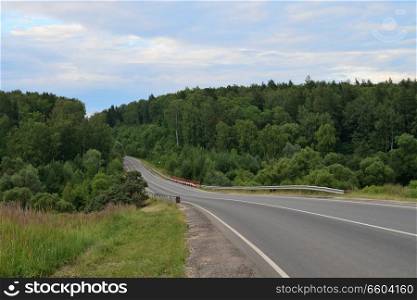 Summer landscape with a rural road and forest. landscape with a rural road