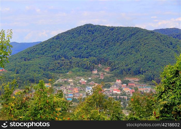 Summer landscape with Caucasus mountains and small town