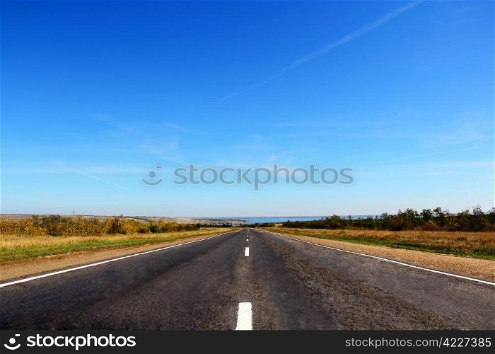 Summer landscape with line of road and blue sky